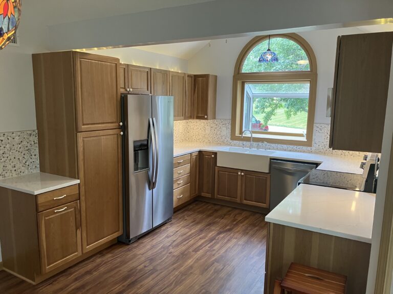 Full remodeled kitchen with custom cabinetry, new flooring, farmhouse sink and quartz countertops in Merriam, KS.